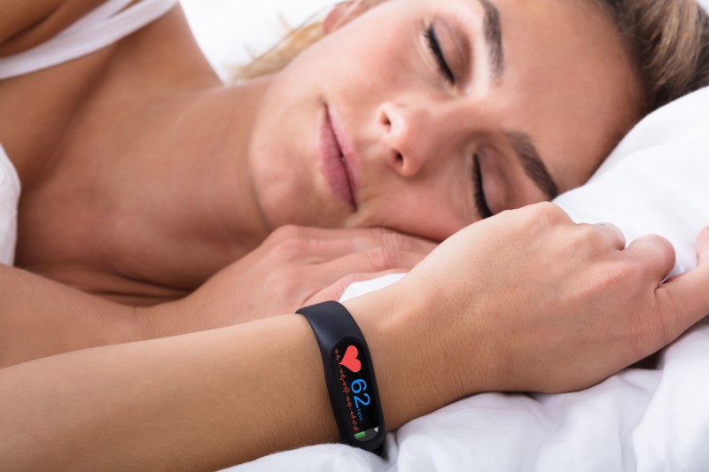 Fitness Tracker trackt Schlafqualität von schlafender Frau